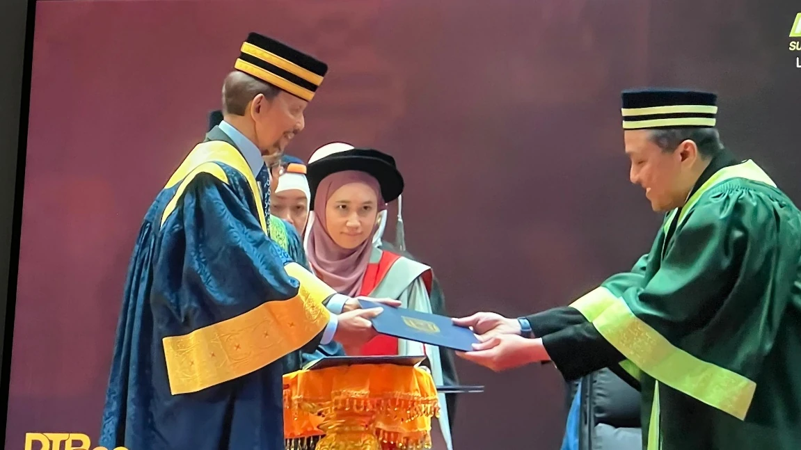 Ahmad Zaldi Assegaf menerima dokumen akademik pada prosesi kelulusan di Universiti Brunei Darussalam